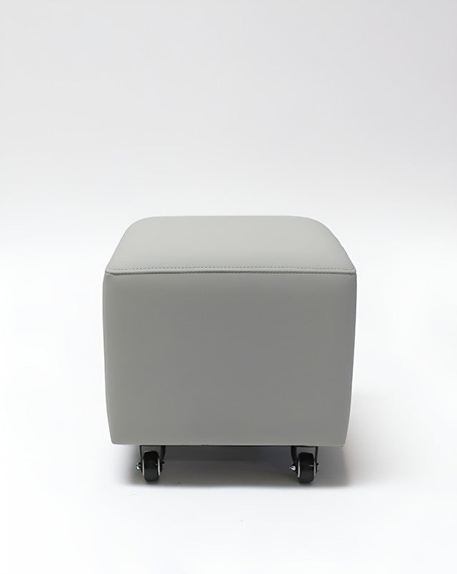 The Belava Nail Tech Stool - Shorty is a gray rolling ottoman, ideal for salons and spas.