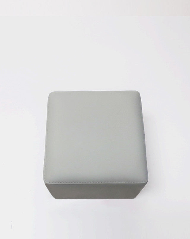 The Belava Nail Tech Stool - Shorty is a square, light gray salon ottoman on a white background.