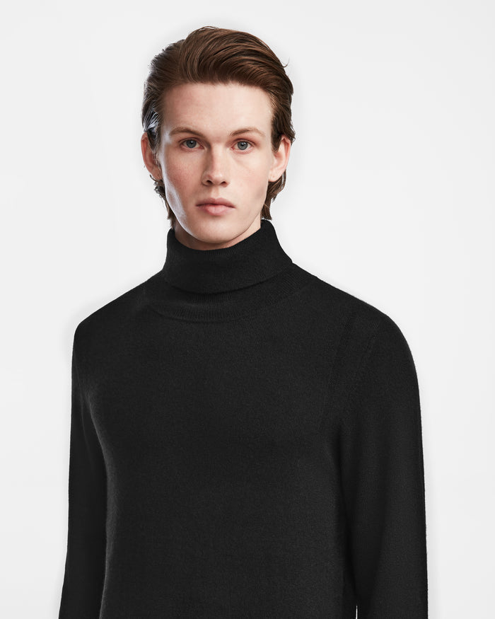 A man in the Rudsak NICOLAS - 6524528 Black turtleneck sweater exudes timeless style and sophistication.