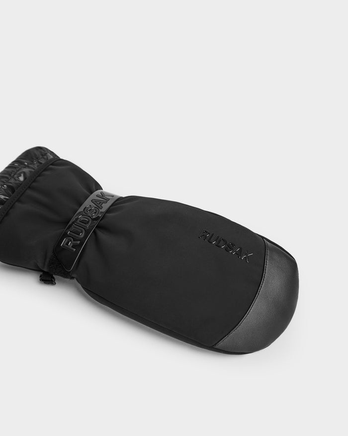 The Rudsak OLTEN - 9425565 Black winter mitten features a leather palm, leather trim, 3M Thinsulate insulation, and Rudsak embossing—ideal for anyone seeking premium ski mittens or winter gloves. Shown on a plain white background.