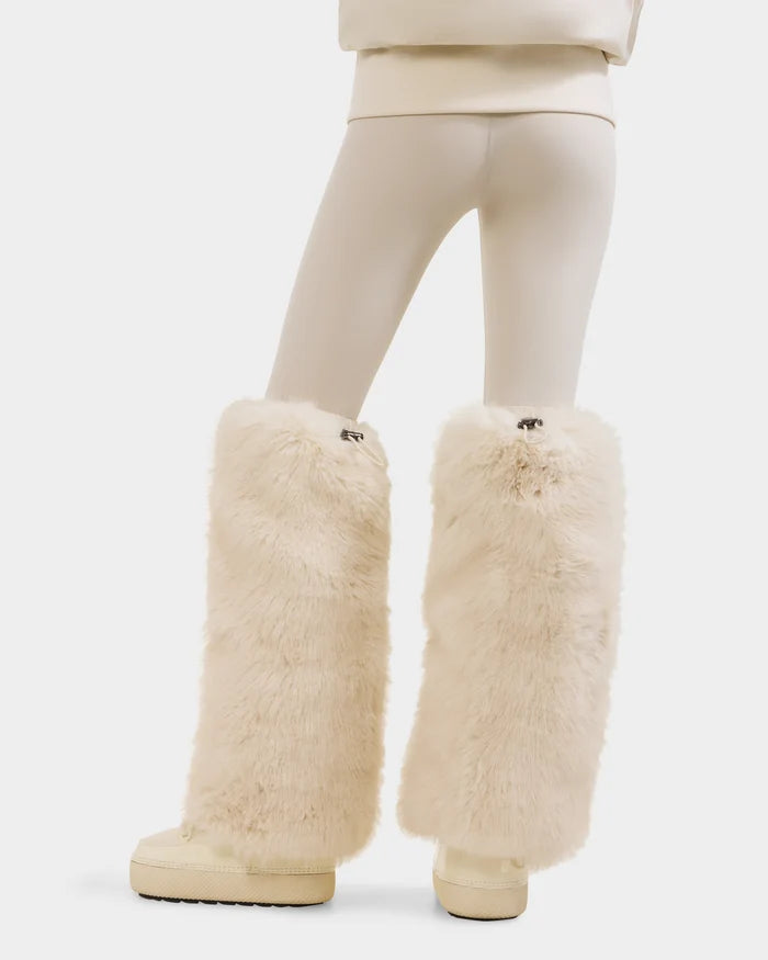 A person wearing Rudsak PAIGE - 8425534 Vanilla cream leggings and matching oversized faux fur leg warmers with cream shoes, shown from the back against a plain white background.