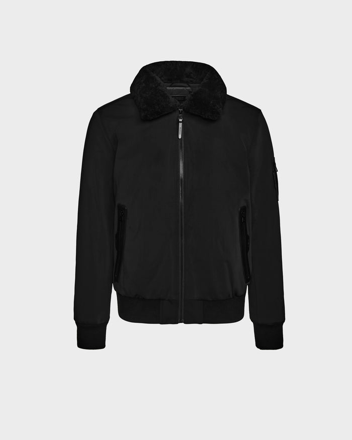 The Rudsak REECE - 6124592 Black mens bomber jacket features a front zipper, shearling collar, two zippered side pockets, and ribbed cuffs and hem, shown on a plain white background.