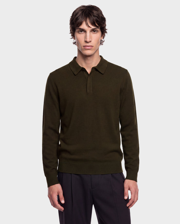 A young man stands facing forward with a neutral expression against a plain light gray background, wearing the Rudsak RICHARD - 6524529 Olive men’s knit polo sweater and black pants.