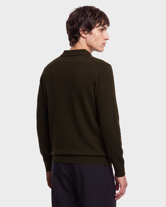 A person with short brown hair, wearing the Rudsak RICHARD - 6524529 Olive men’s knit polo sweater and black pants, stands facing away and looks over their left shoulder against a plain white background.