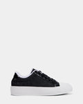 The Rudsak RIMA - 8225001 Black Pattern is a black monogram print sneaker featuring a white rubber sole and toe cap, black laces, and subtle logo detailing on the side, shown against a plain white background.