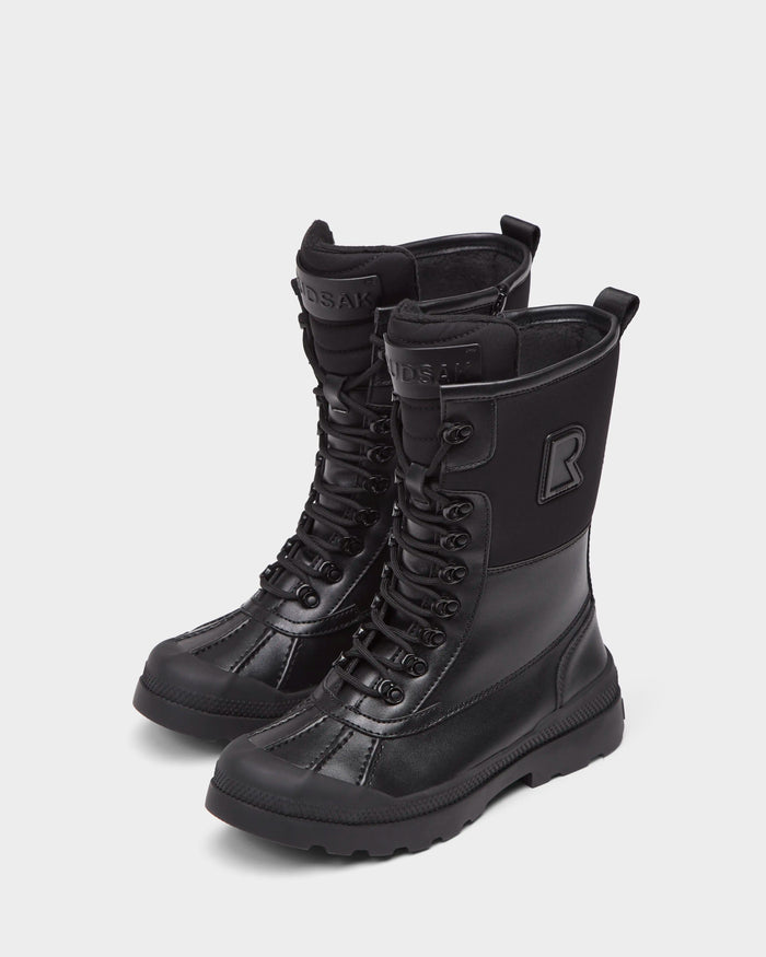 The Rudsak RITA - L222502 Black are women’s mid-calf lace-up winter boots in black weather-treated leather, with rugged soles, a bold R logo, a cozy faux fur insole, and shown on a plain white background.