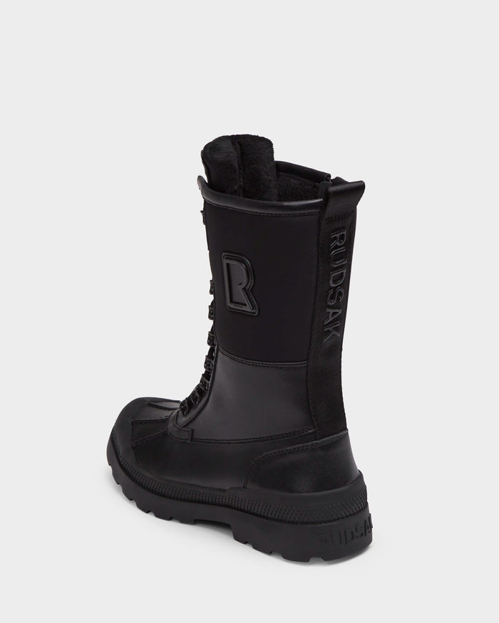 The RITA - L222502 Black by Rudsak is a women’s winter boot crafted from weather-treated leather with a thick sole, textured toe, lace-up front, soft faux fur insole, R on the side, and RWDSAK on the heel.