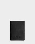 The Rudsak ROBIN - 9425562 Black is a unisex leather travel wallet featuring the brand name in silver at the bottom center, shown against a light gray background. This stylish passport holder is perfect for your travels.