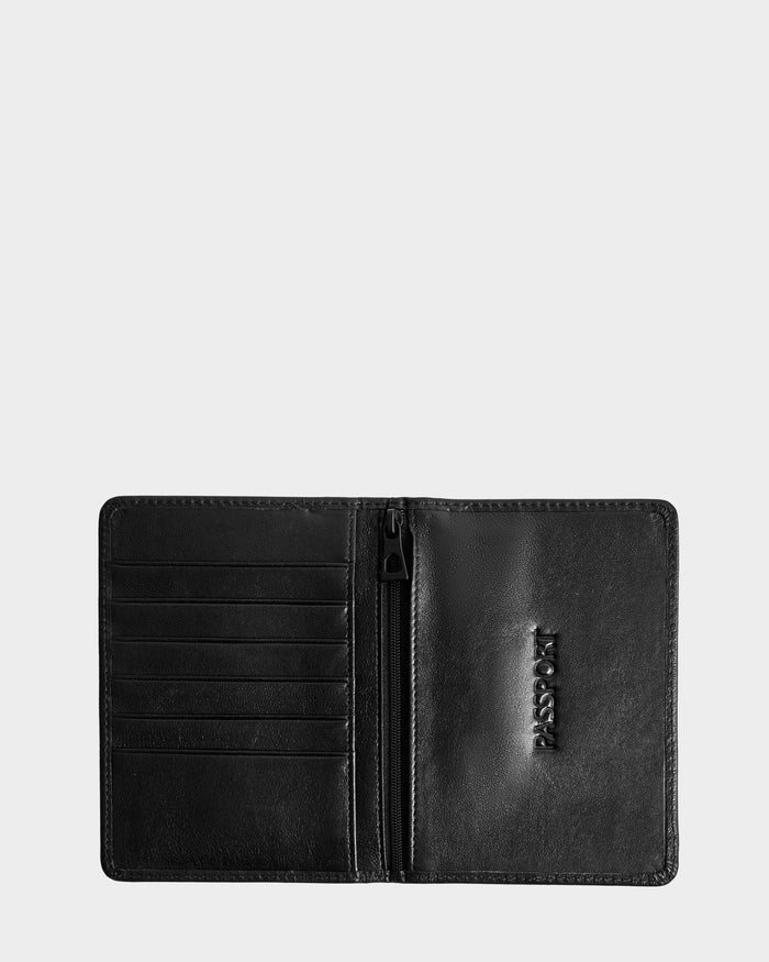 The Rudsak ROBIN - 9425562 Black unisex passport holder is displayed open against a plain light gray background, showing card slots on the left, a zippered pocket in the center, and a PASSPORT section on the right.