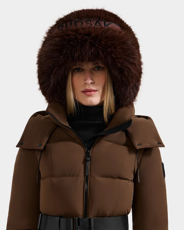 A woman with straight blonde hair and a neutral expression models the Rudsak ROMINA - 8425545 Espresso puffer jacket, featuring a large, fluffy fur hood, against a plain light background—showcasing cozy winter style.