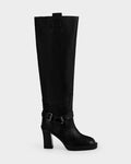 The Rudsak ROSSEY - 8225574 Black is a tall black leather heeled boot featuring a rounded toe, ankle buckle strap, and top pull tab, displayed against a plain light background.