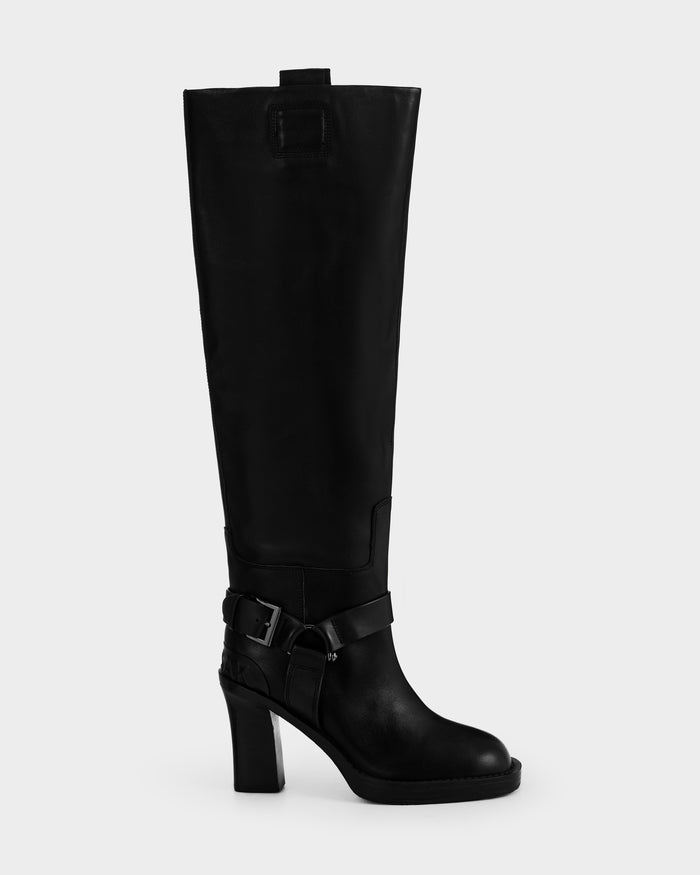 The Rudsak ROSSEY - 8225574 Black is a tall black leather heeled boot featuring a rounded toe, ankle buckle strap, and top pull tab, displayed against a plain light background.