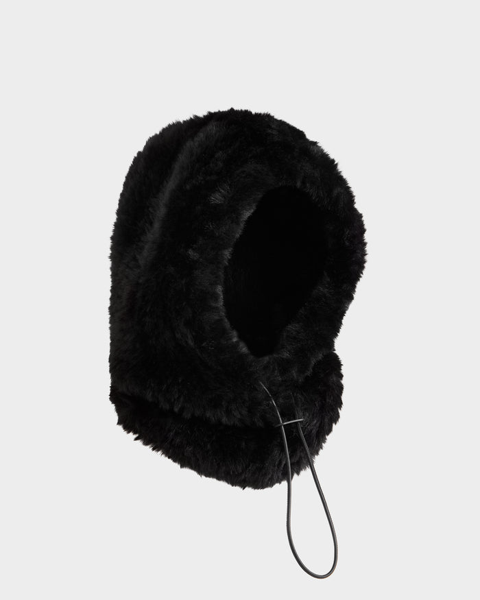 The Rudsak TARA - 8425025 Black women’s balaclava features soft black faux fur, a rounded design, and an adjustable drawstring front opening, showcased against a plain light gray background.