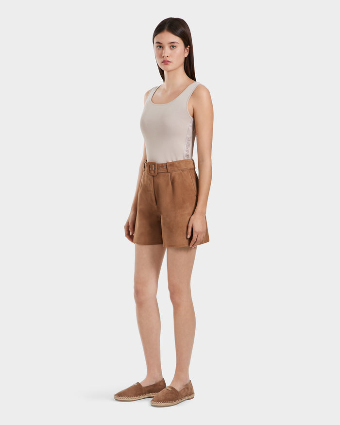 A woman wears Rudsaks TERRIE SU - 8525053 Almond high-waisted tailored suede shorts with a belt, paired with a beige sleeveless top and brown espadrilles, standing against a plain white background.