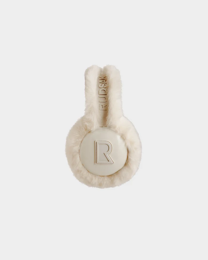 VALENCIA - 8425543 Vanilla by Rudsak: Beige faux fur earmuffs featuring a large R logo on the ear cover and RUDSAK embroidery on the headband, styled as a chic winter accessory against a plain white background.