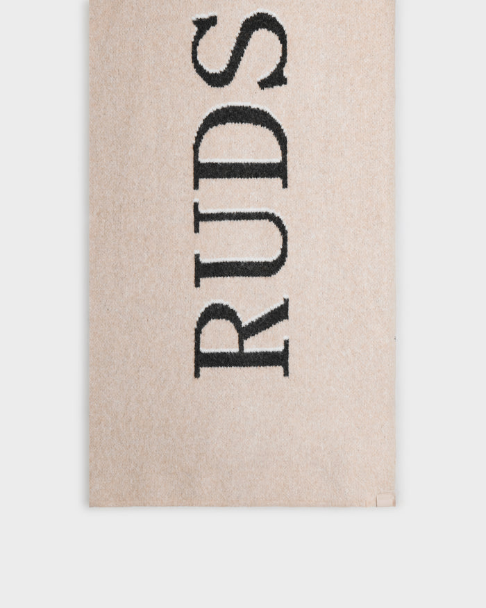 The WYATT - 6425039 Vanilla rug by Rudsak features bold, black, vertical branding on a beige background—an essential accent for your winter style. Shown on a plain white background.