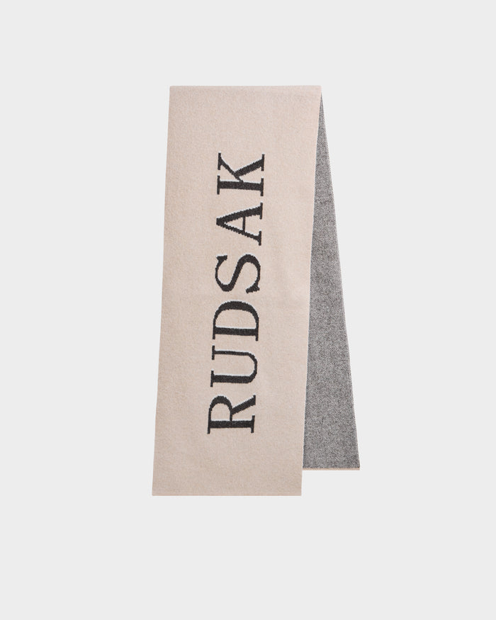 The WYATT - 6425039 Vanilla men's scarf by Rudsak features beige and gray tones with bold vertical black RUDSAK lettering—an essential cold-weather accessory to elevate your winter style.