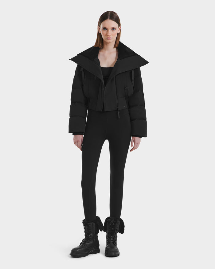 A woman in the Rudsak YVETTE - L125557 Black, a stylish women’s cropped down jacket with an oversized collar, made from RDS-certified down.