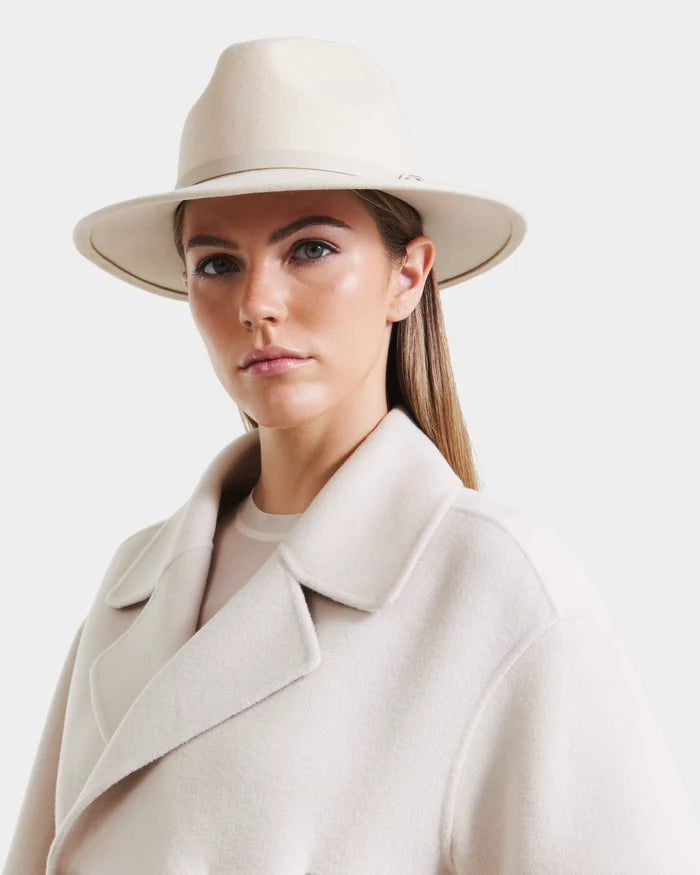 A woman in a Rudsak ZELDA - 8425536 Vanilla wool fedora and matching light coat gazes neutrally at the camera against a plain light background.