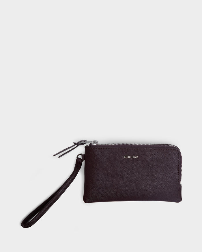 The ZURIE - L424501 wristlet wallet by Rudsak features wine-colored leather, zippered compartments, a detachable strap, and RUDSAK in small silver letters on the front, shown against a plain white background.